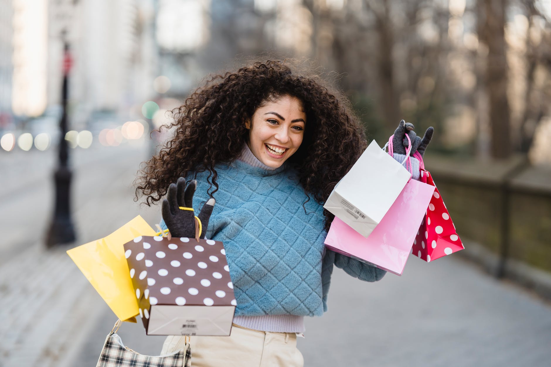 cheerful shopper with bright gift bags smiling