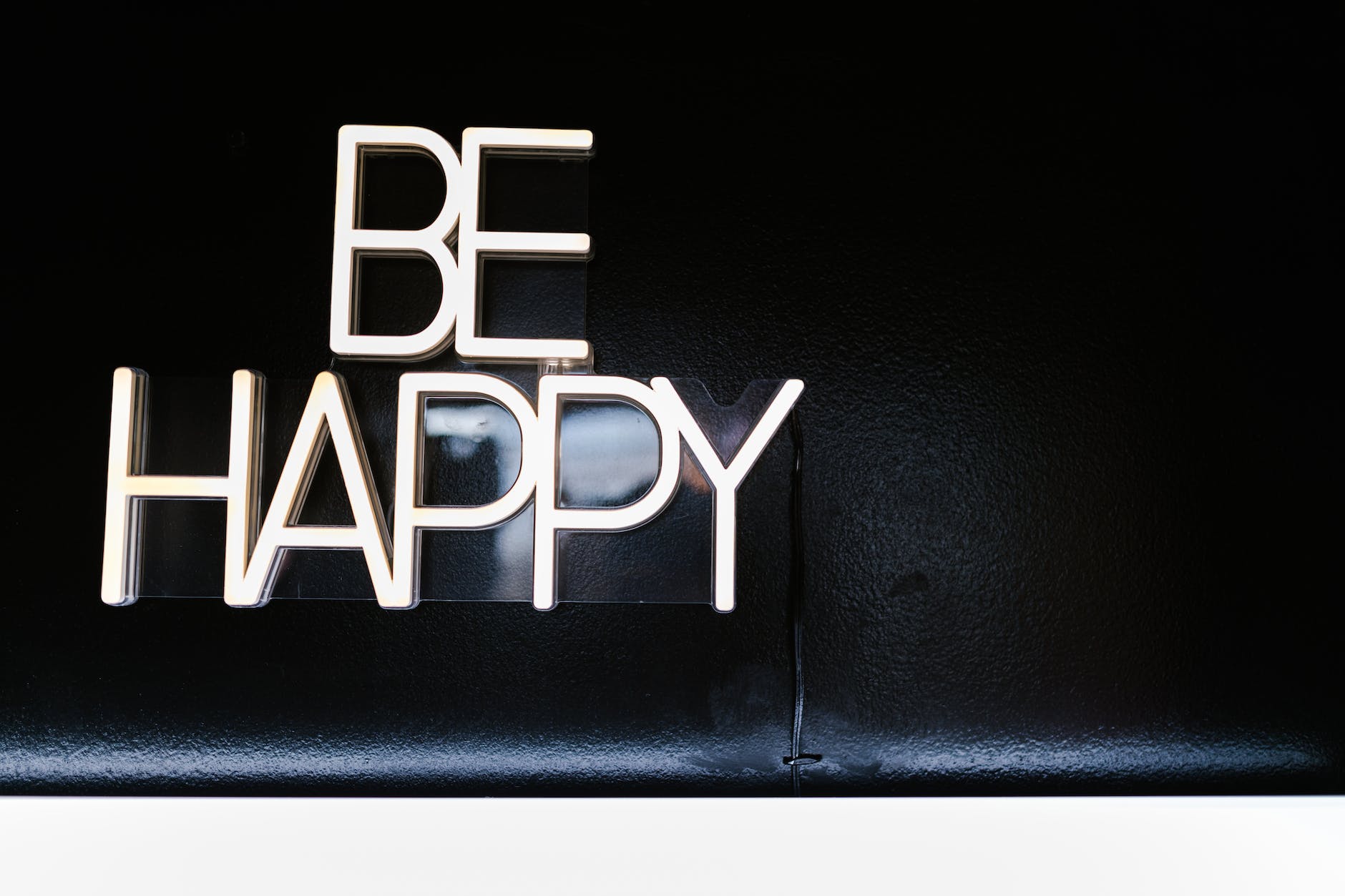 neon sign saying be happy